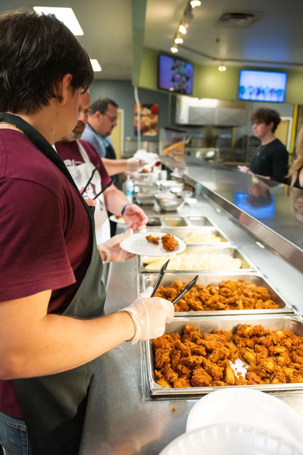 Dning hall serving line with employees standing behind counter waiting for students