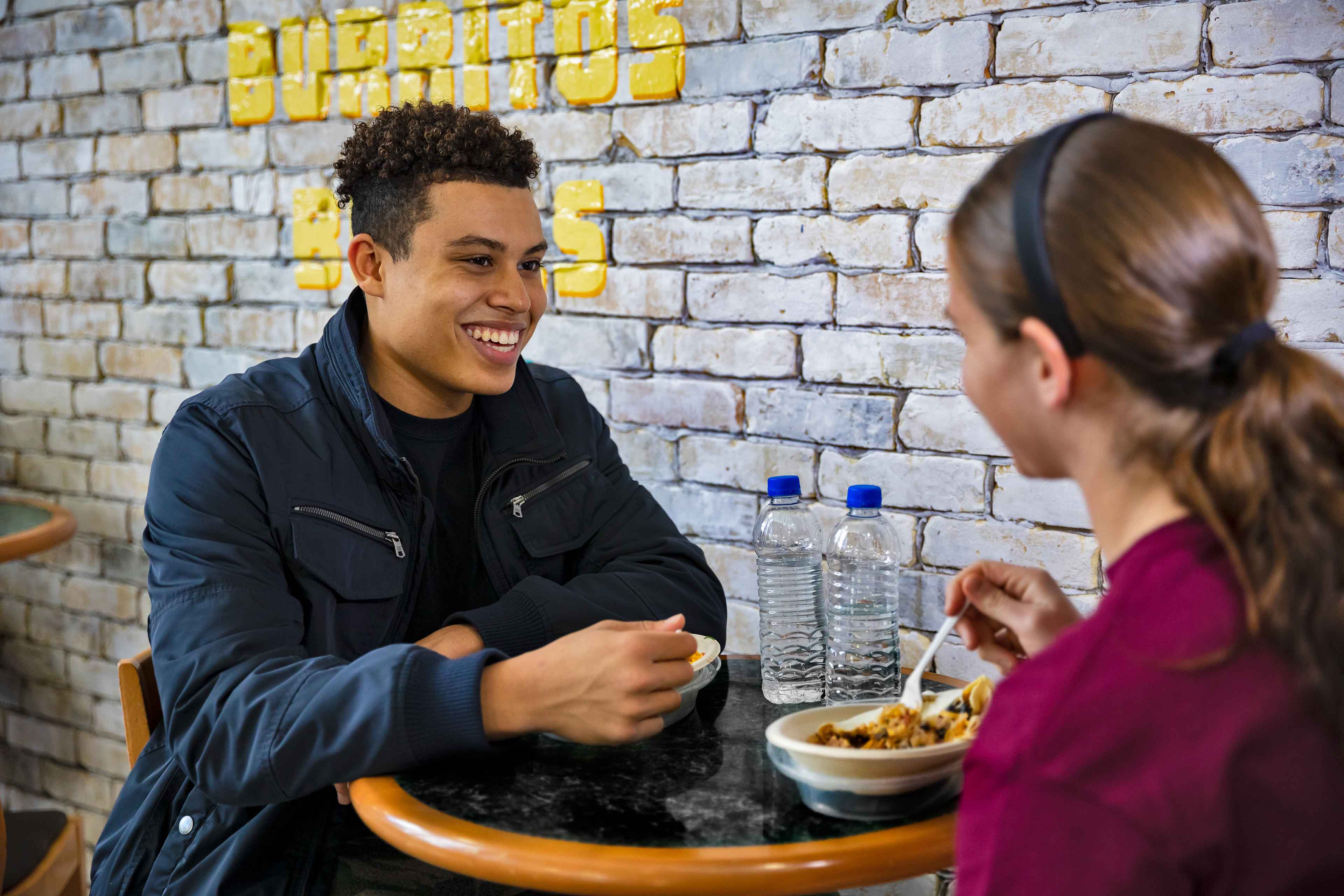 Two students sitting at table enjoying a meal